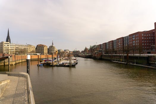 Explore Hamburg's historic architecture along the bustling port with iconic buildings and moored boats.